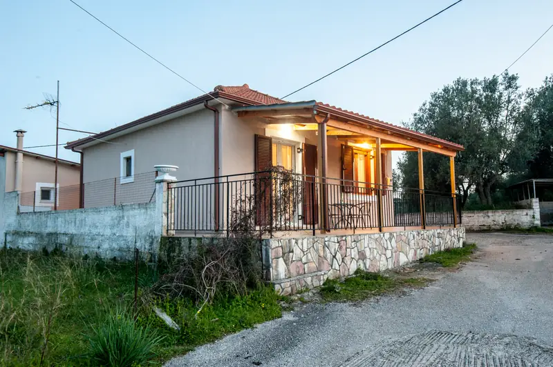 The house at dusk, with the veranda lit