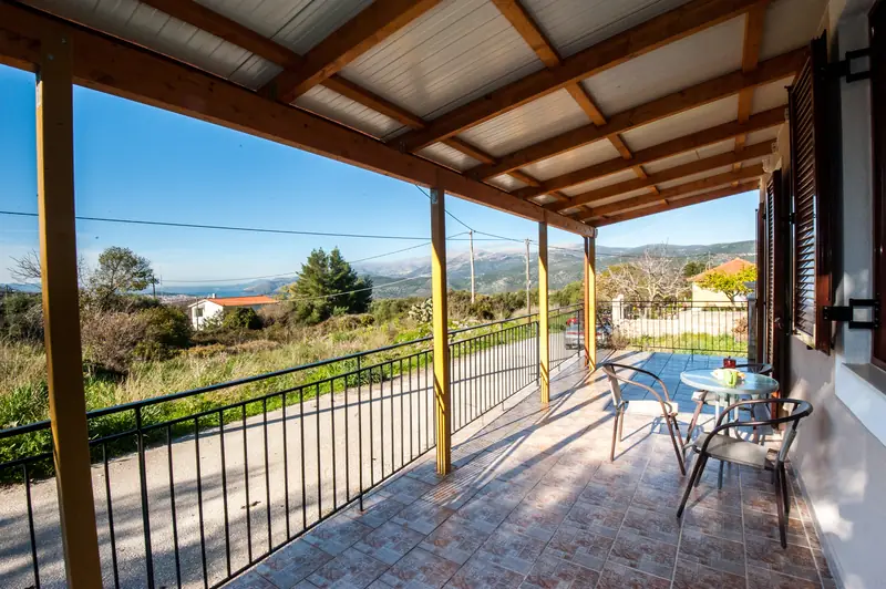 Brown shutters and a table on the veranda