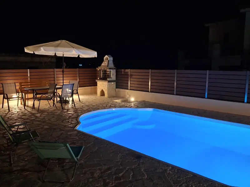The stone paving and wooden fence around the pool